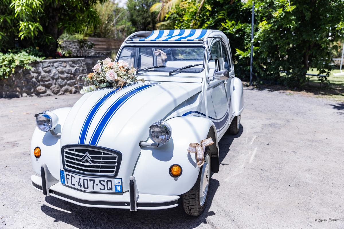 La 2CV de trois quarts devant un mur de pierres, prête pour la sortie